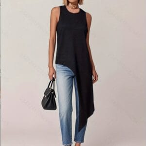 A young woman stands confidently against a plain gray background, dressed in a black tank top and blue jeans with her hands.