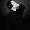 Immersive headphone portrait highlighting COCOLOGO sustainable fashion and eco-conscious knitwear craftsmanship