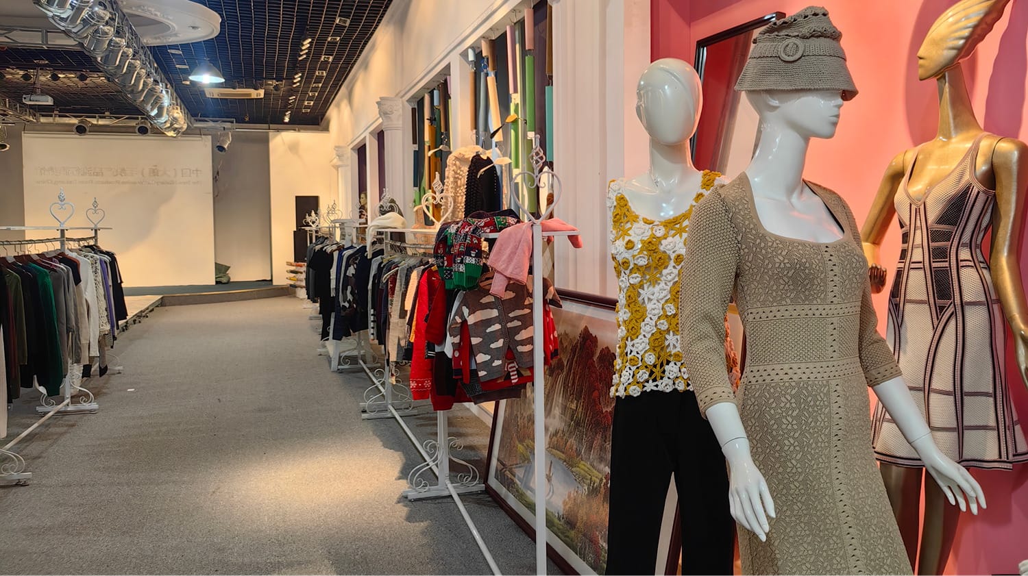 A clothing showroom with two mannequins dressed in unique attire, one of which is wearing a hat and the other.