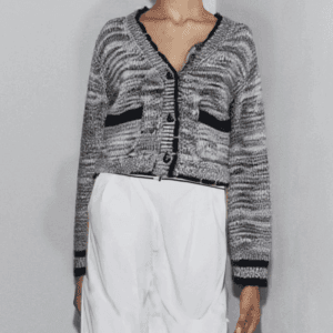 A person is standing against a plain white wall.